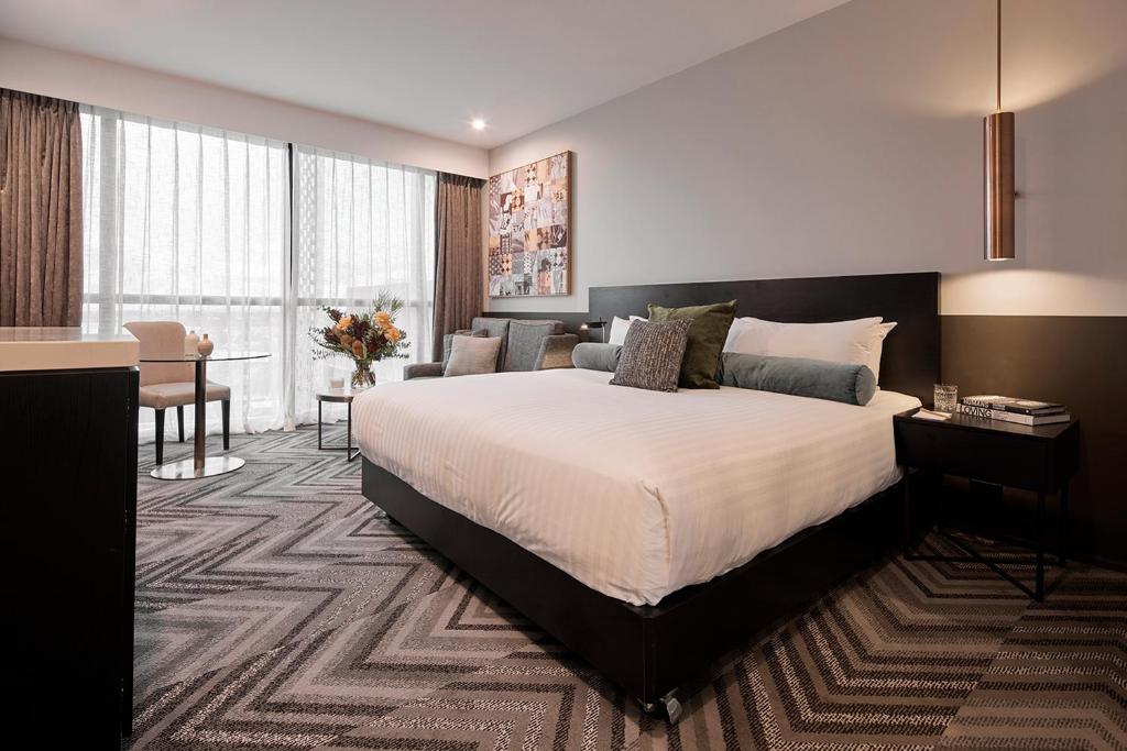 珀斯Rydges Perth Kings Square的酒店客房设有一张大床和一张书桌。