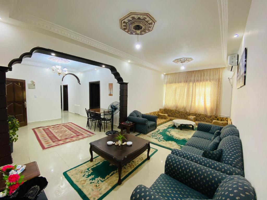 安曼شقه مفروشة الجبيهه的客厅配有蓝色的沙发和桌子