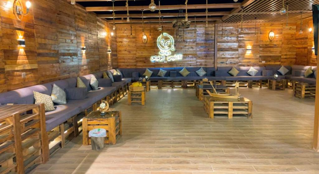 利雅德إستراحة الدنيس الونيس的餐厅设有蓝色的沙发和木墙