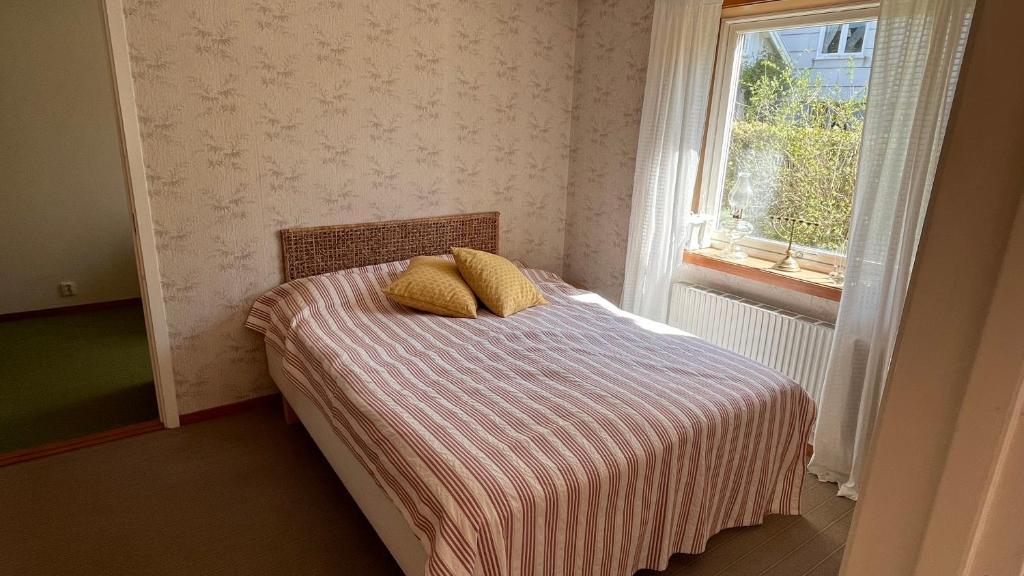 埃勒斯Ellös Holiday apartment的一间卧室配有带两个枕头的床和窗户