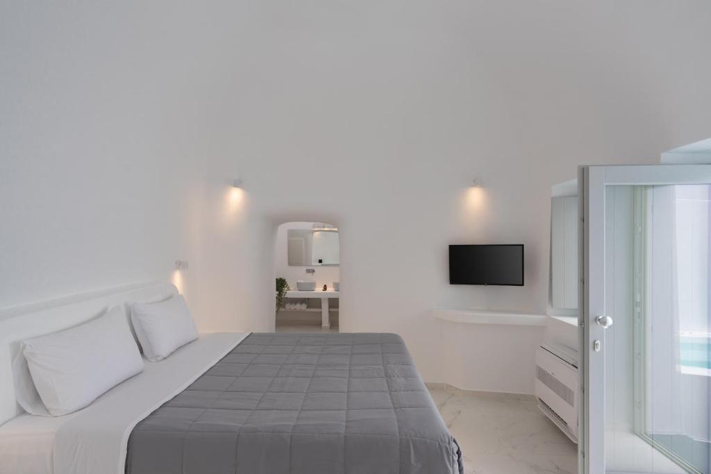 费拉White Concept Caves的一间白色卧室,配有床和电视