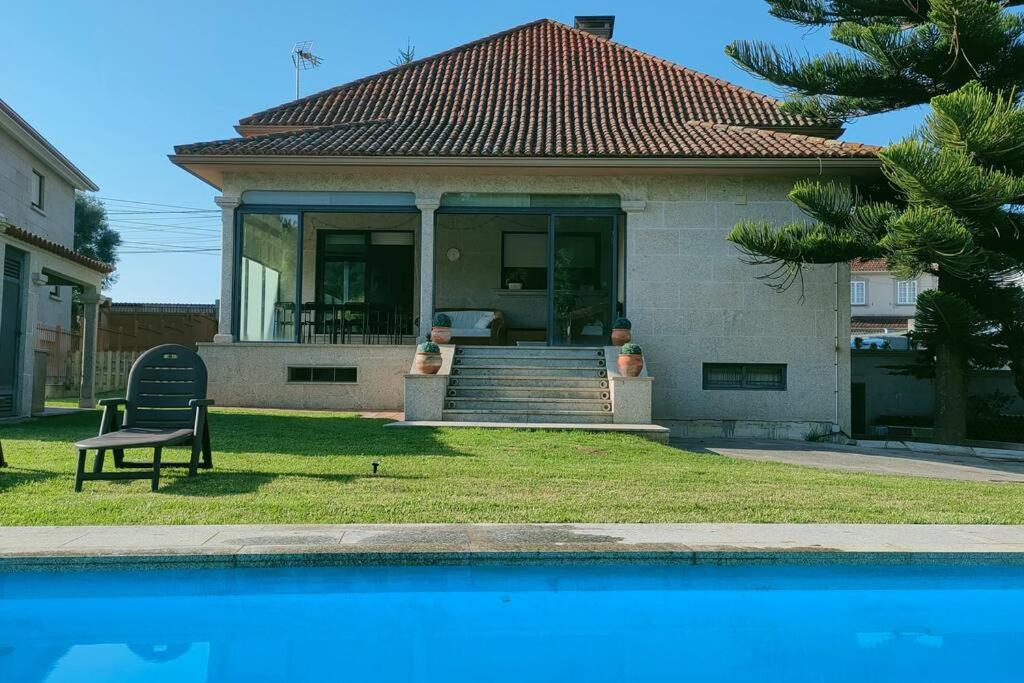 维戈Gran casa pareada con piscina en Vigo. Playa: 9min的游泳池旁带长凳的房子