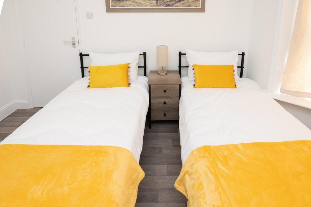 南安普敦Brinton's Road - Modern Studio Apartments in City Centre的配有黄色枕头的客房内的两张床