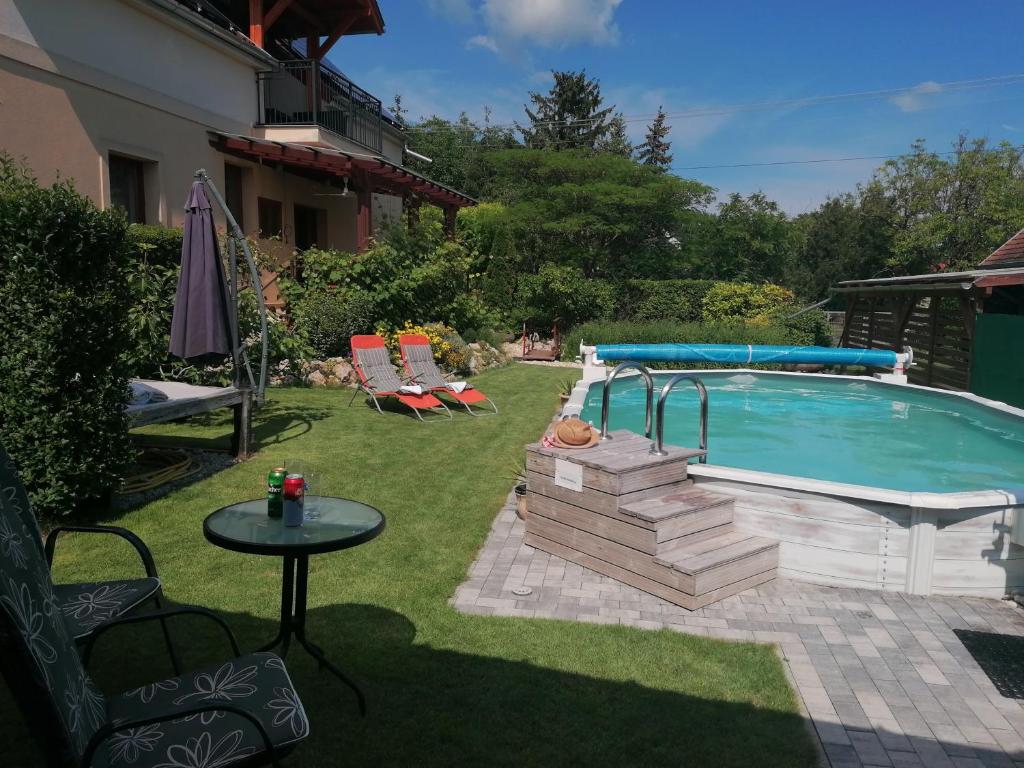 根尼斯迪亚斯Marianna Apartman的庭院内的游泳池,配有桌子和桌子