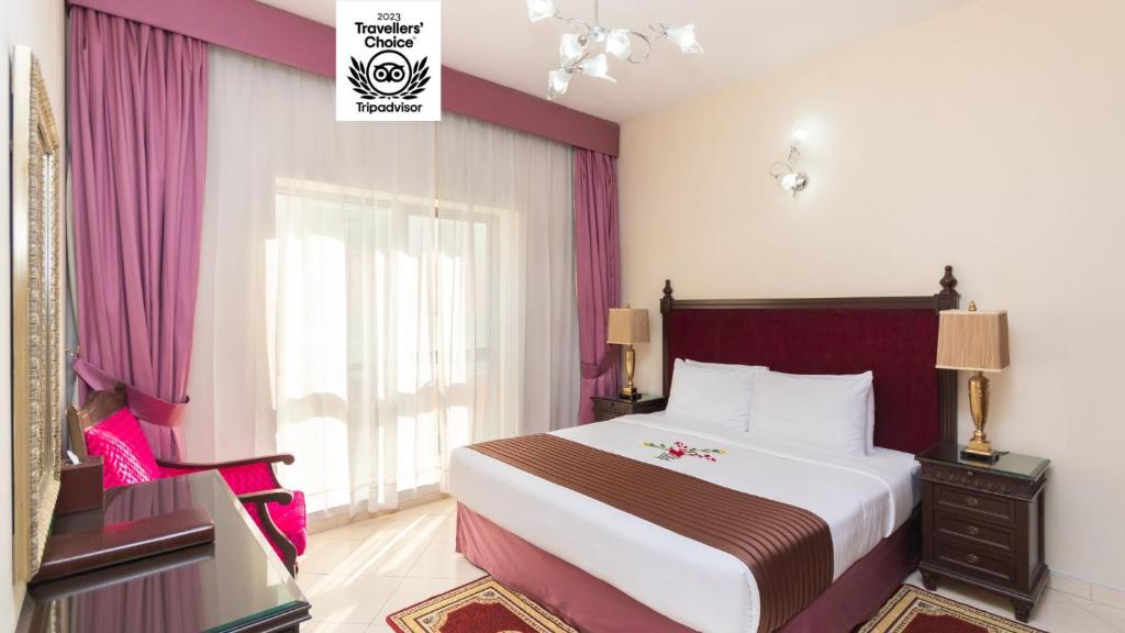 迪拜Auris Boutique Hotel Apartments - AlBarsha的酒店客房设有床、梳妆台和窗户。