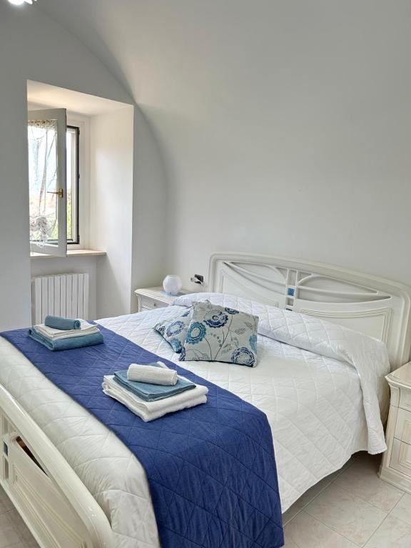 PacentroLa Minicasa的卧室配有白色床和毛巾