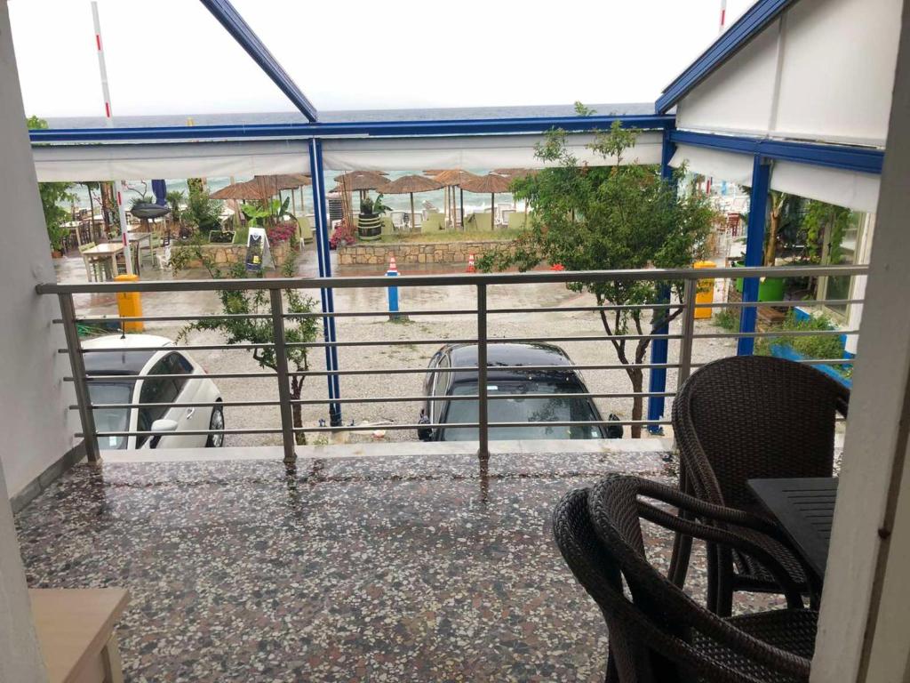 波利克罗诺Casa Real beach的阳台配有椅子,享有停车场的景致。
