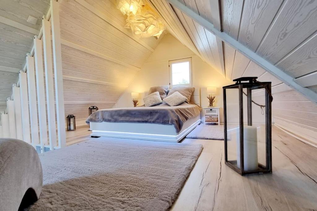 阿贡库坦维尔O bulles d'Agon Chalet Spa privé Plage的木制客房内的一间卧室配有一张大床
