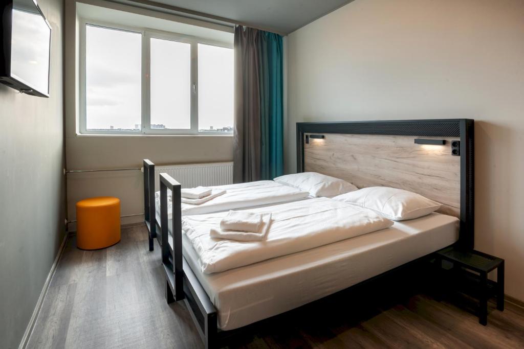 哥本哈根a&o Copenhagen Sydhavn的一间卧室配有一张带白色床单的大床