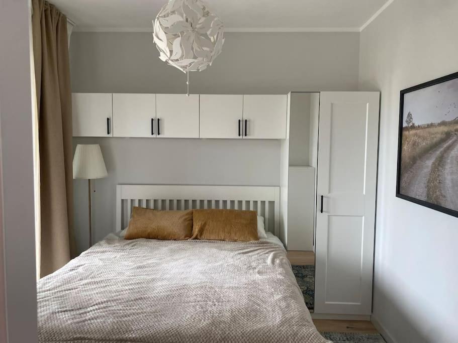 ĶesterciemsAlbatross_resort_alejaa的白色卧室配有一张床和一个吊灯