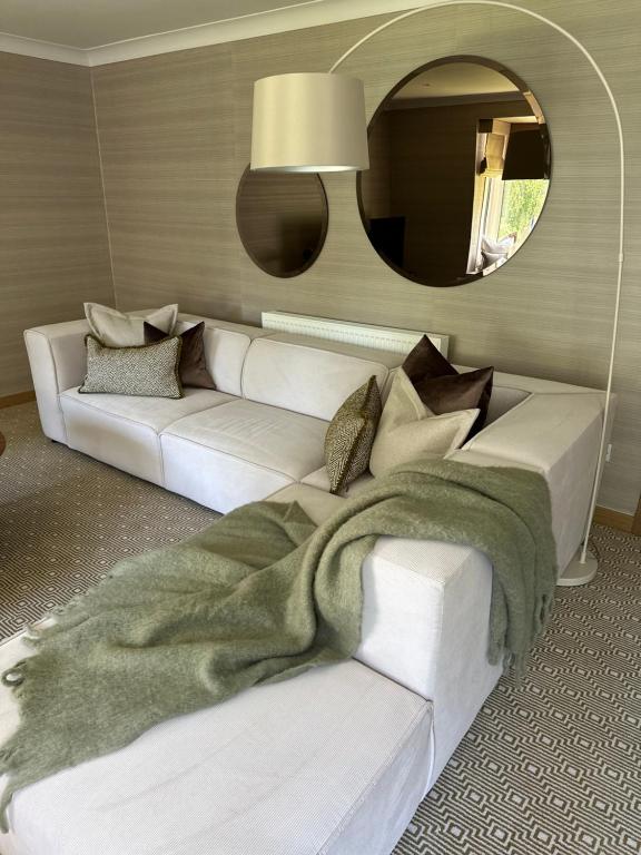 奥赫特拉德Gleneagles Holiday Home Rental的客厅配有白色沙发和镜子
