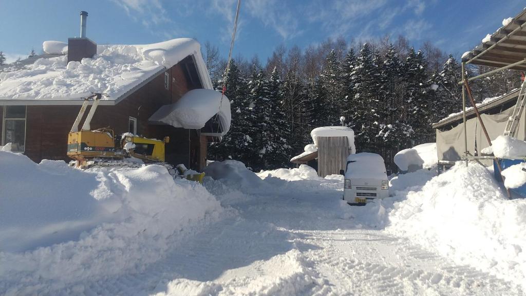 赤井川Ski base的一座有房子和卡车的雪地堆积的院子