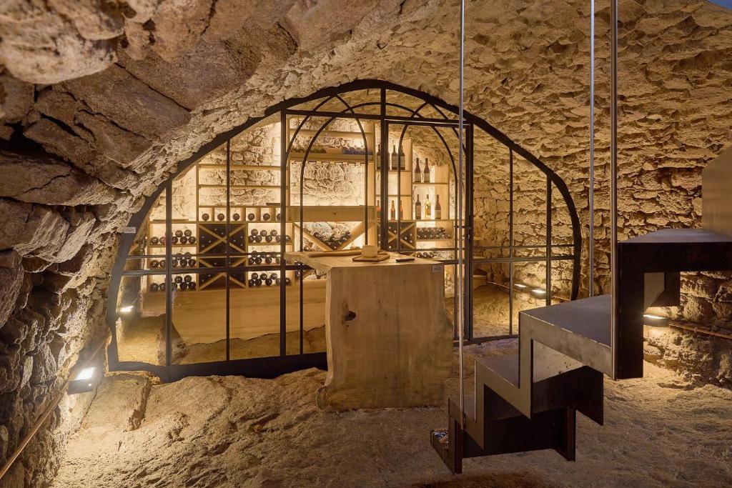 蒂福日Gîte Des Caves Secrètes的石墙内有笼子的品酒室