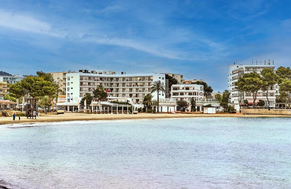 埃斯卡纳Leonardo Suites Hotel Ibiza Santa Eulalia的海边的一座建筑