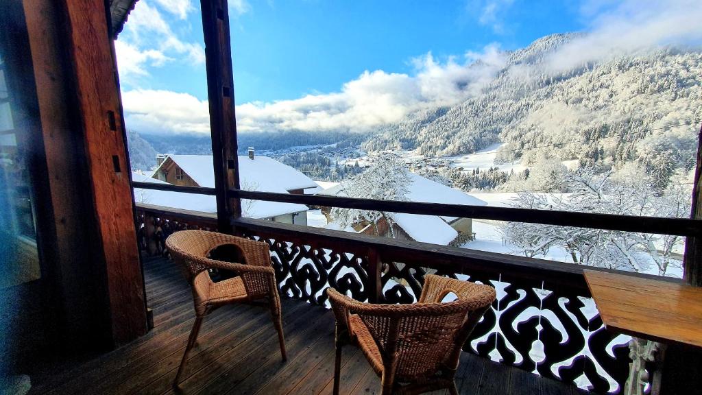 圣让多尔普Chalet Liberte的阳台配有两把椅子,享有雪覆盖的山脉美景。