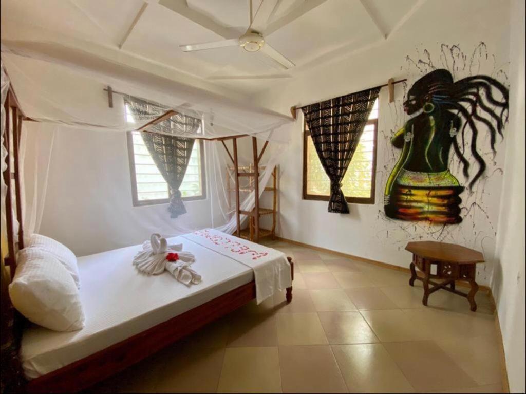 南威Wakanda Nungwi的卧室配有一张床,墙上挂有绘画作品
