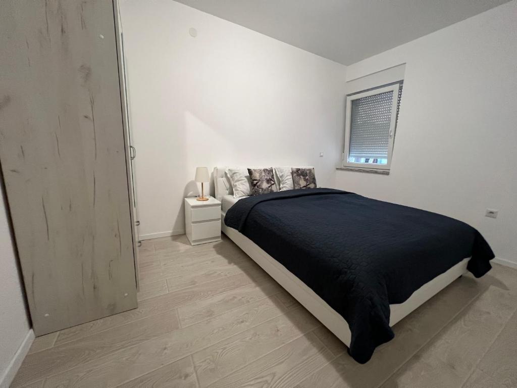 维罗维蒂察Apartman Panonica的白色的卧室设有床和窗户