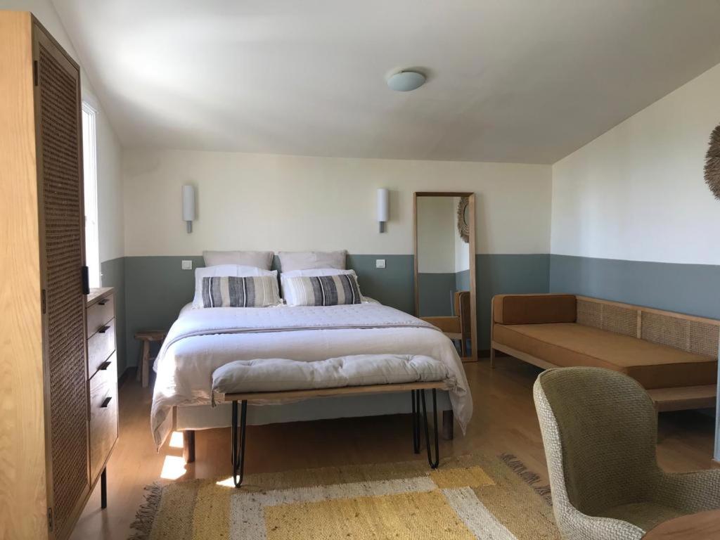 Saint-Michel-lʼObservatoireL’OBSERVATOIRE的一间卧室配有一张床、一张沙发和一把椅子