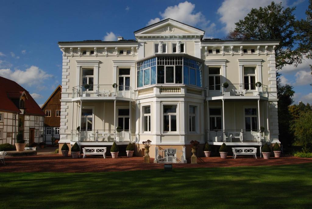 哈姆古特昆普贾斯特隆梅酒店的一座大型白色房子,设有大院子