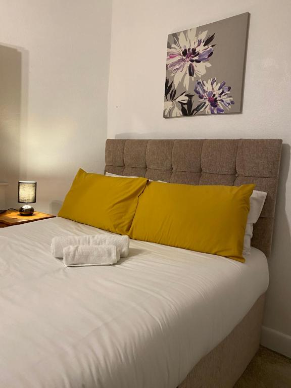 南安普敦Spacious single and double bedroom in Southampton with free parking的一间卧室配有一张带黄色枕头的床