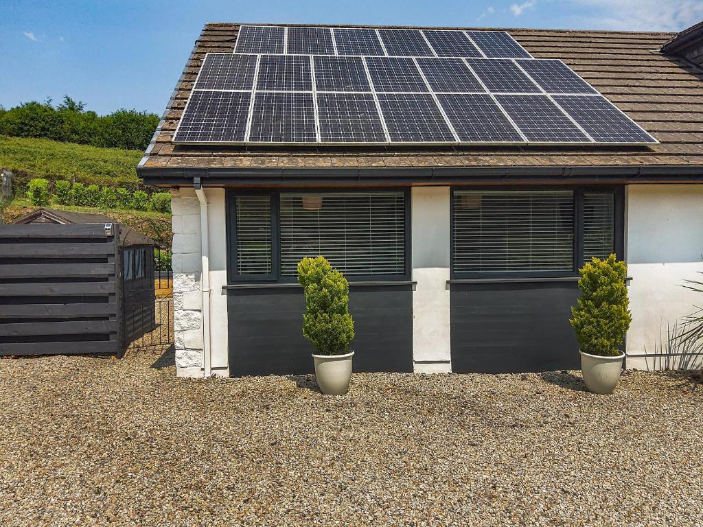 DobwallsPetersfield Farm Bungalow Annexe的屋顶上设有太阳能电池板的房子
