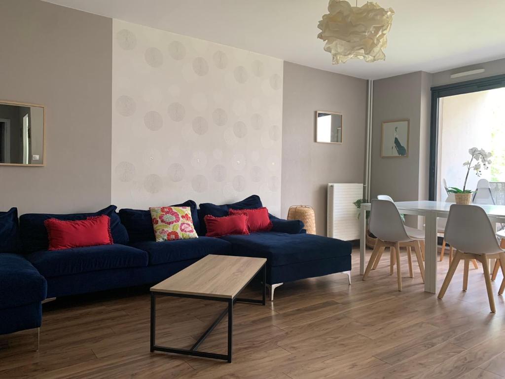 布雷斯特L'Escale - appartement spacieux au calme的客厅配有蓝色的沙发和桌子