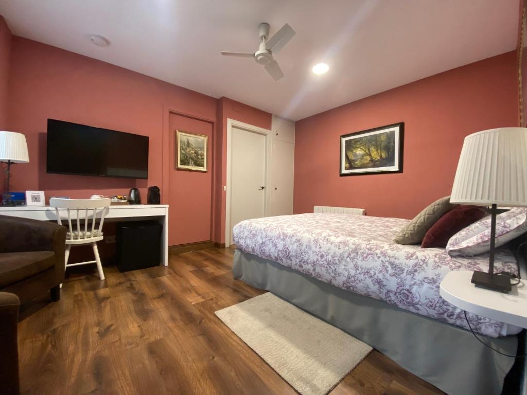 圣朱利亚德维拉托Escloper B&B的一间卧室配有一张床、一张书桌和一台电视。