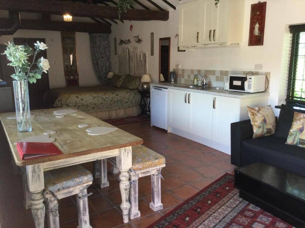 灵格弗尔德The Garth Guest Suite Studio Cottage的厨房以及带桌子和沙发的客厅。