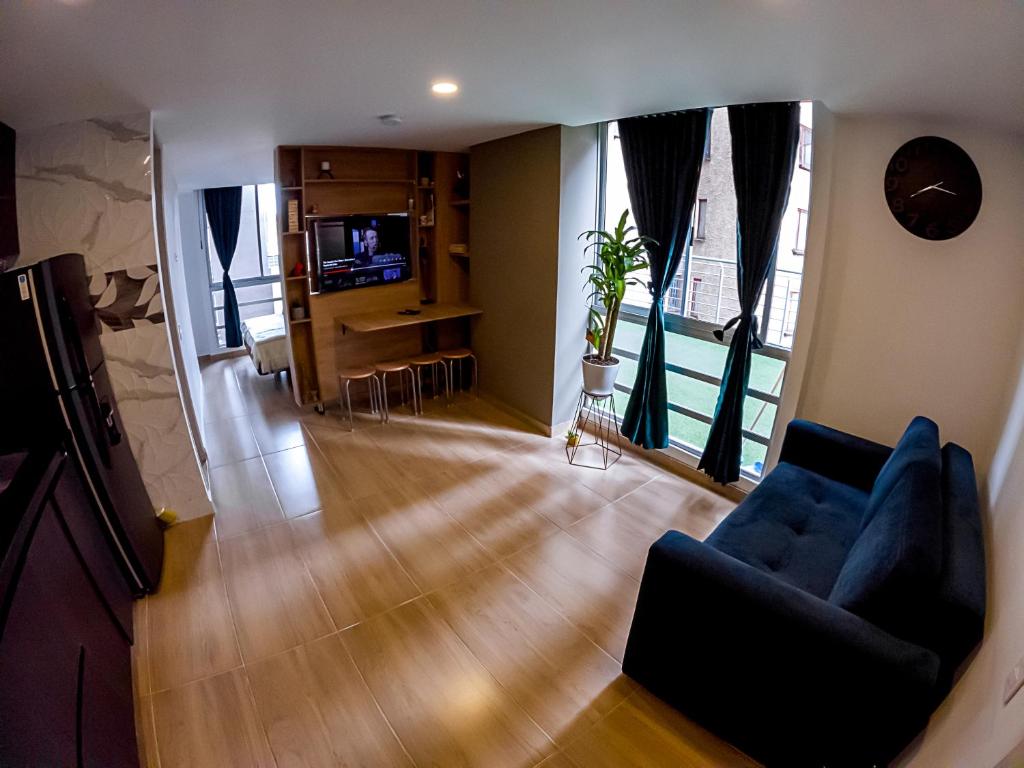 波哥大Cómodo apartamento tipo Loft en centro de Bogotá 5的客厅配有蓝色的沙发和电视