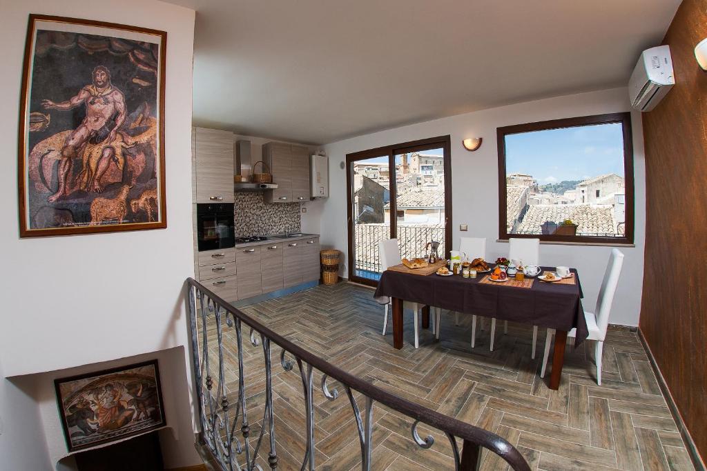 皮亚扎-阿尔梅里纳Umberto 33的厨房以及带桌子和窗户的用餐室。