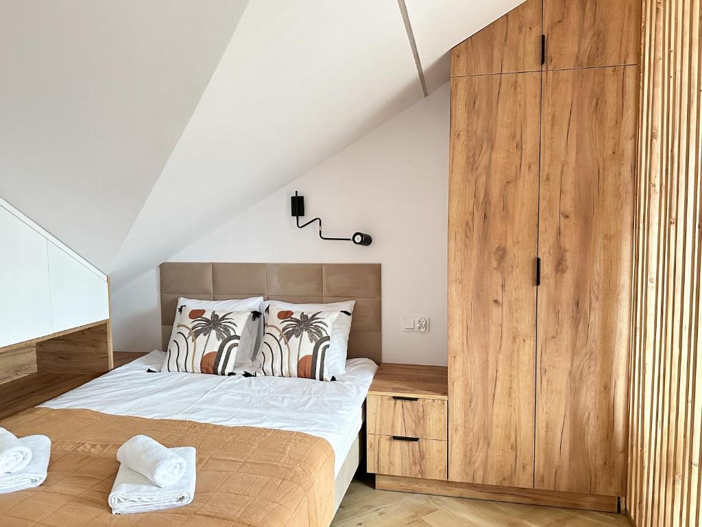 马佐夫舍地区新庄园DMK Oak Studio near Warsaw-Modlin Airport的一间卧室配有一张床和一个木制橱柜