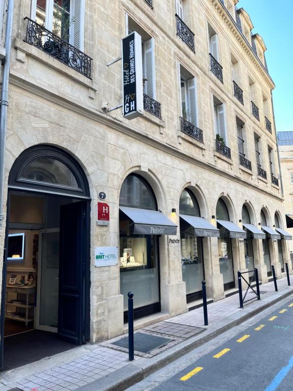 波尔多Brit Hotel Des Grands Hommes - Bordeaux Centre的城市街道上的一座建筑,有商店