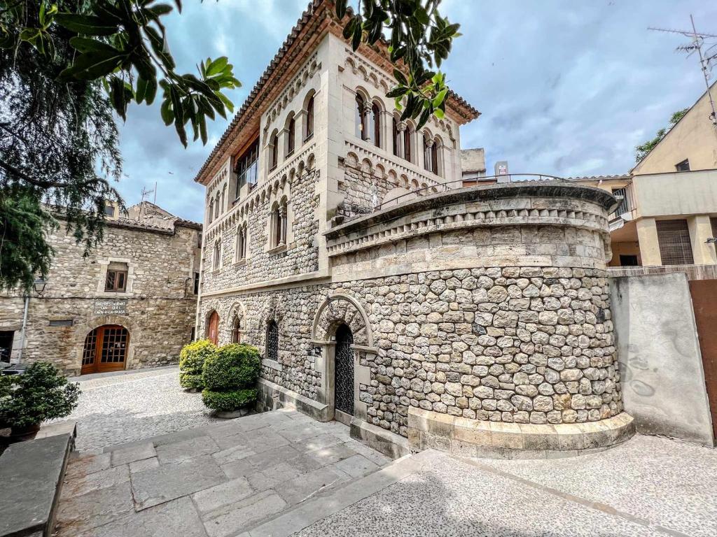 贝萨卢Can Severí casa con historia en Besalú的一座石头建筑,上面有一座塔