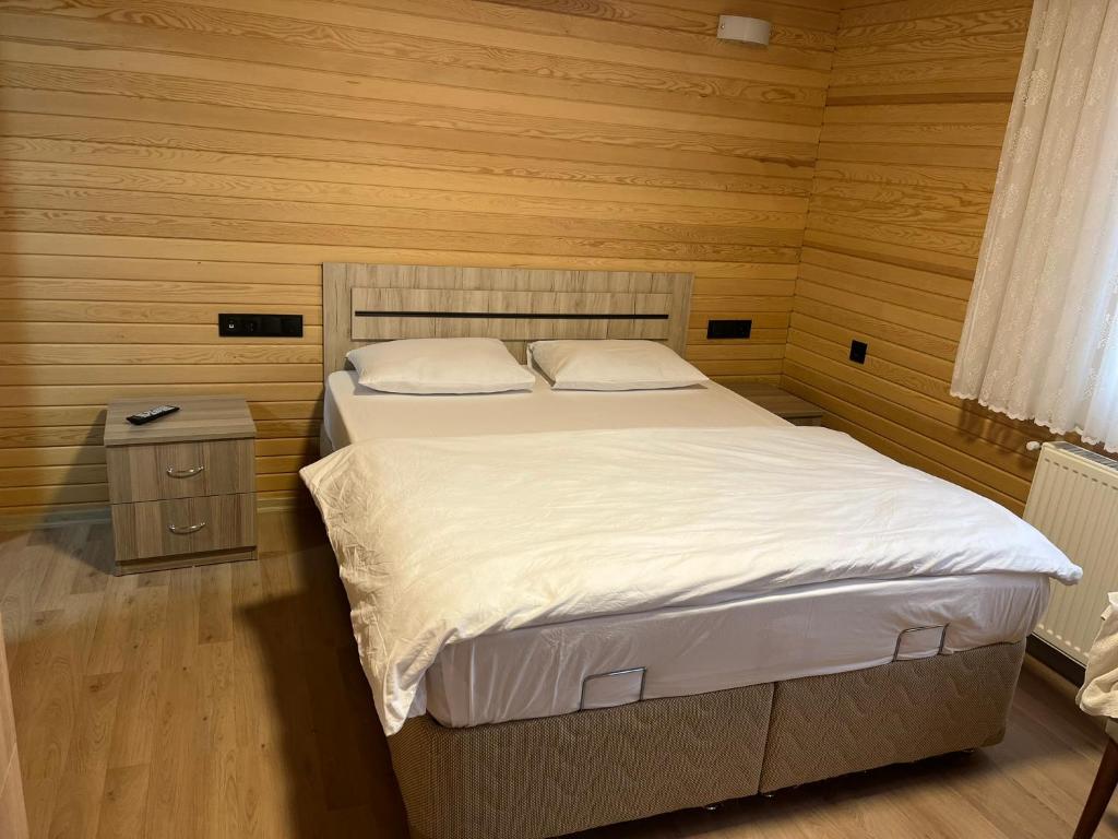 ÇaykaraESPİRA APART的一间卧室设有一张床和木墙