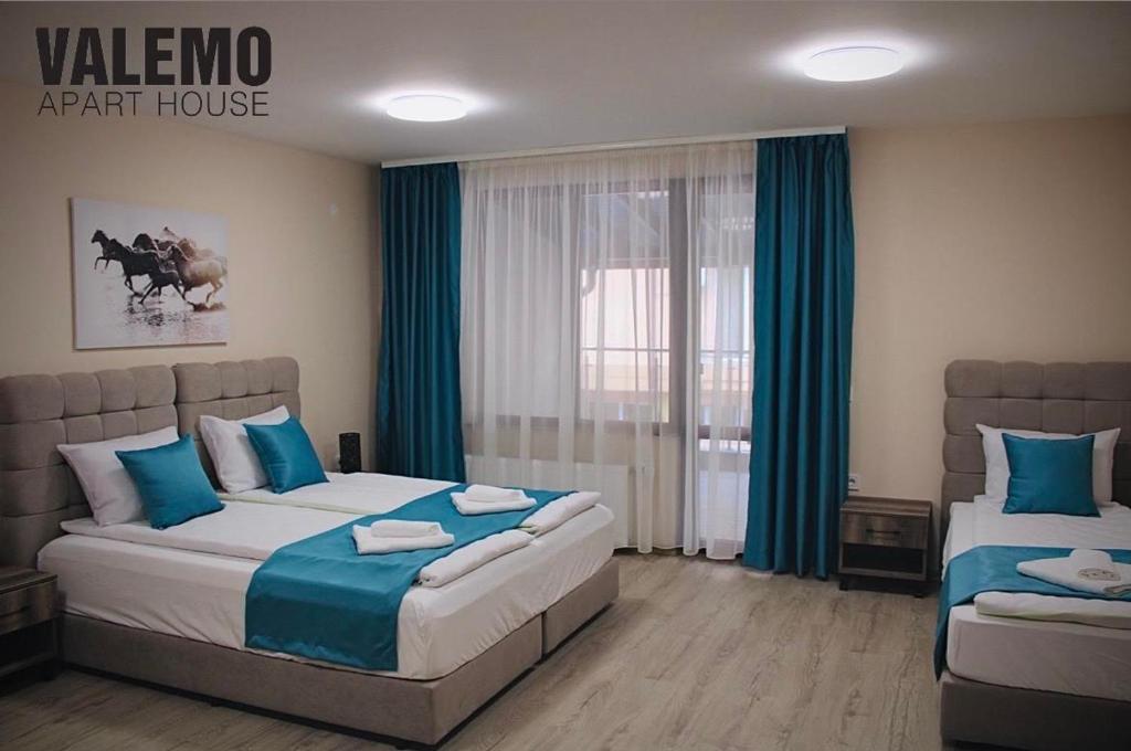 代温VALEMO Apart House的一间卧室配有两张带蓝白色床单的床