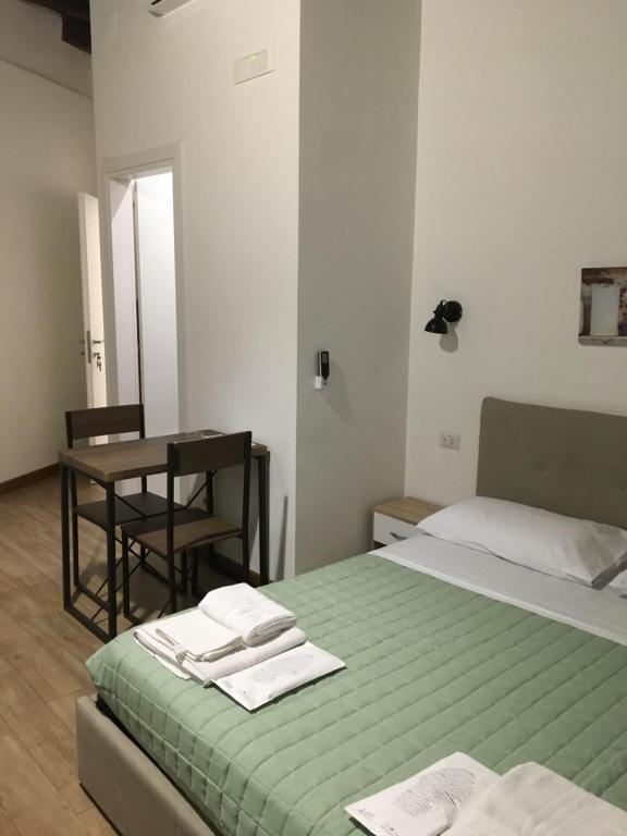 布林迪西Largo Otranto - Guest House的一间卧室配有一张床和一张桌子,上面配有毛巾
