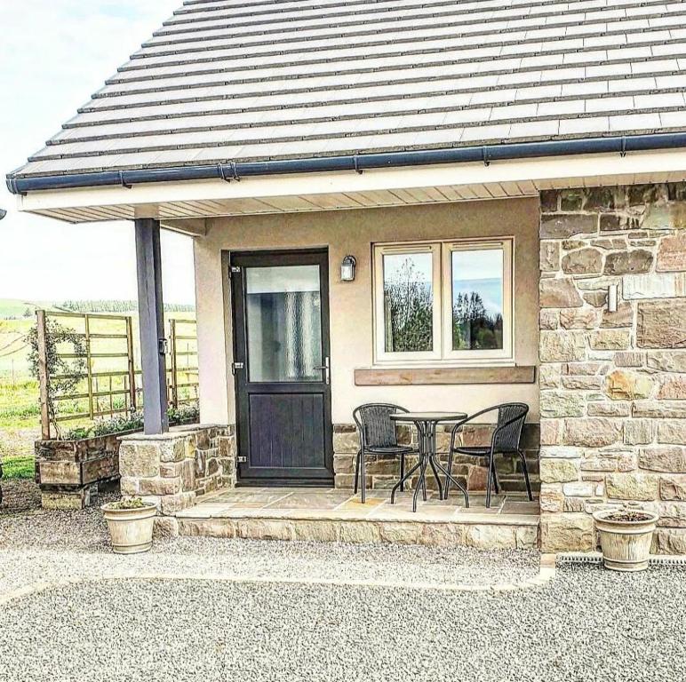 Middleton FossowayThe Wee Stay - Room Only - Rural 1 Bed Guest Suite的门廊上的石屋,配有桌椅