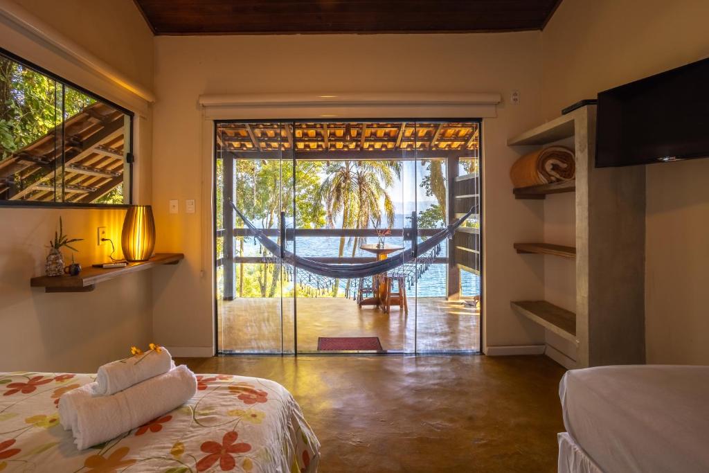 Praia Vermelha拉加马尔旅馆的一间设有床铺和吊床的客房