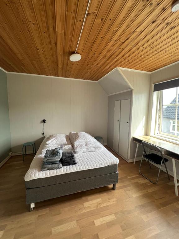 斯沃尔韦尔Koselig hus i havna的一间卧室配有一张木天花板床和一张书桌。