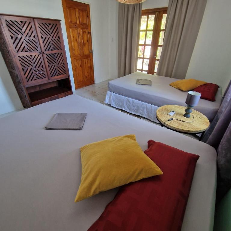 WestpuntNos Soño Stay and Dive的一间卧室配有两张床、一张沙发和一张桌子