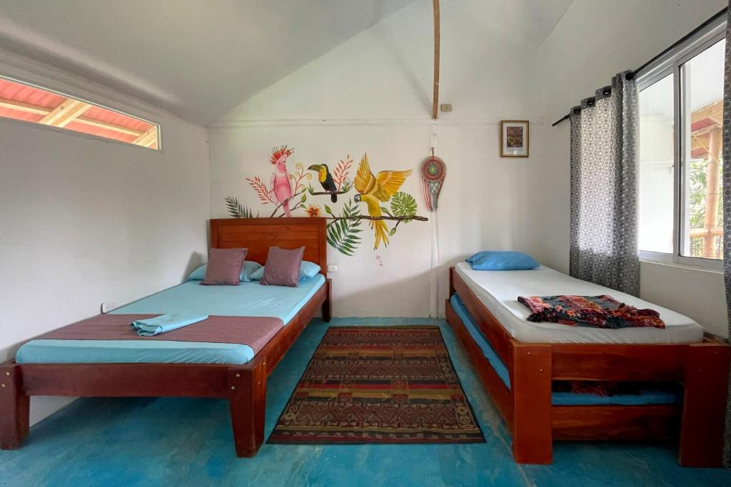 帕洛米诺El Zoo Hostel, Bar & Pool的客房设有两张床和窗户。