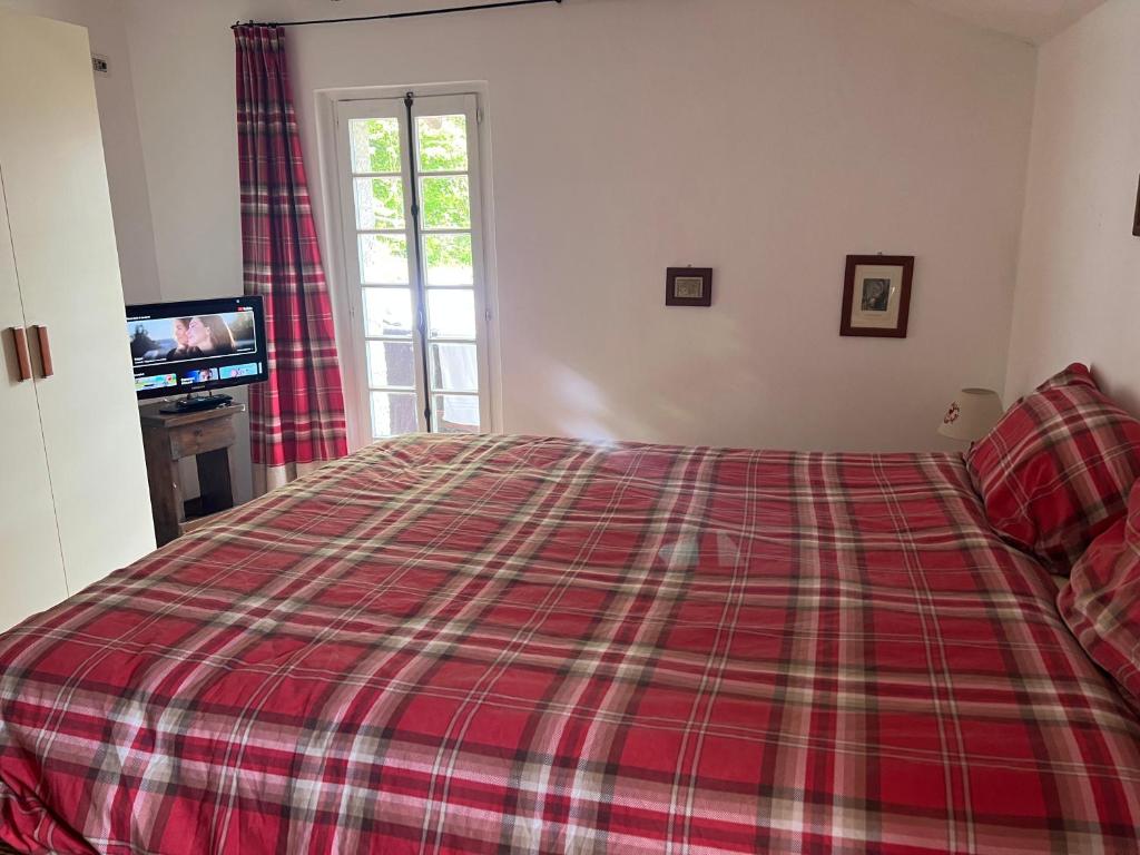 塞里纳Camera matrimoniale con terrazza panoramica的一间卧室配有一张带红色铺面毯子的床
