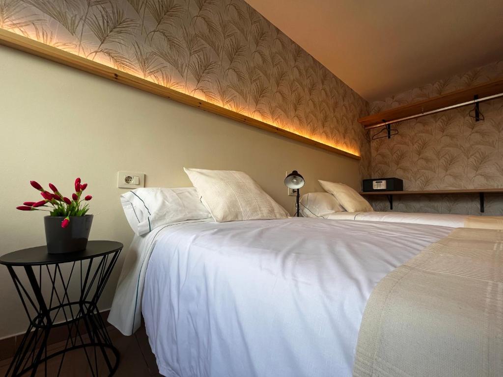 库列雷多Hostal LA POETISA - Auto Check-in的卧室配有一张白色大床和一张边桌