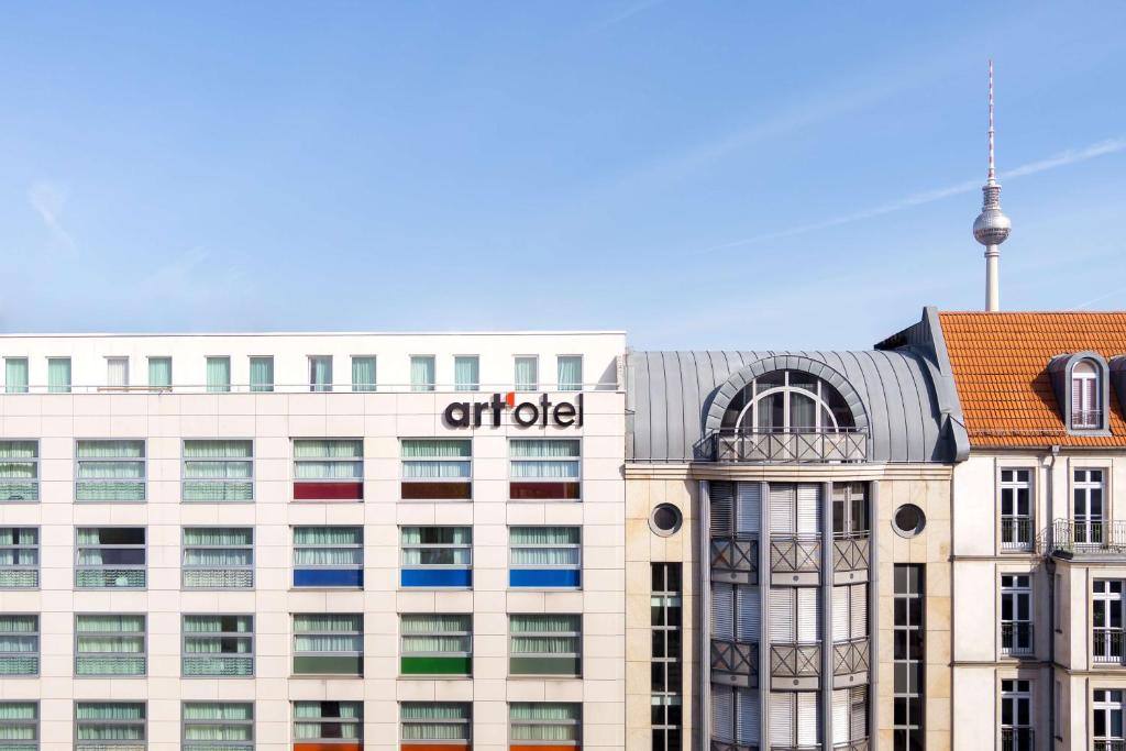 柏林art'otel berlin mitte, Powered by Radisson Hotels的上面有柑橘标志的办公楼