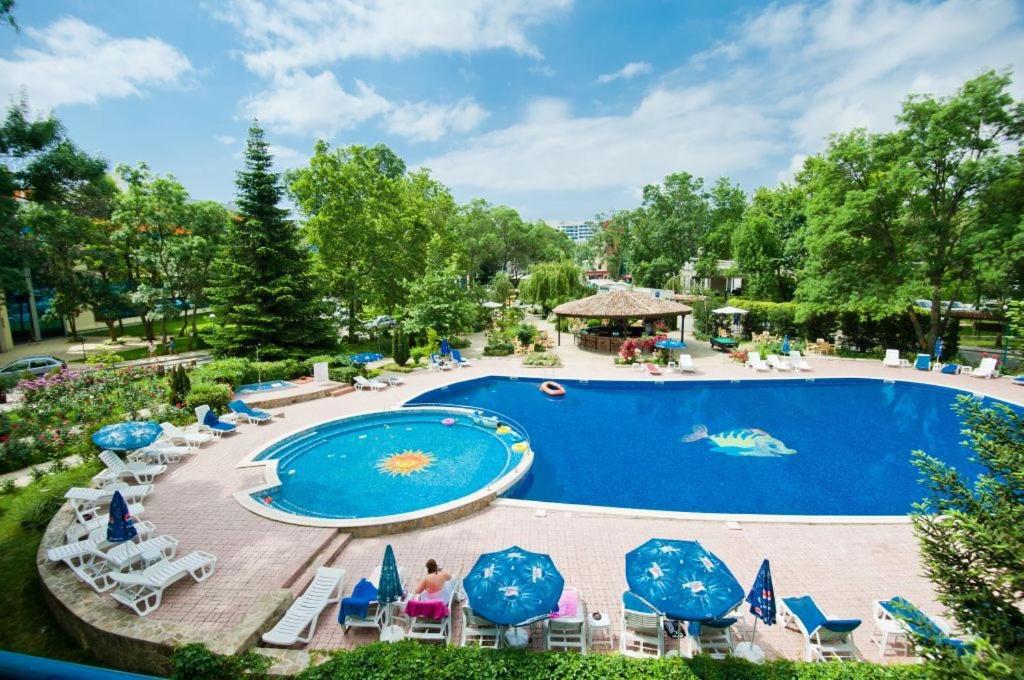 阳光海滩瑞加纳酒店的度假村的游泳池,配有椅子和遮阳伞