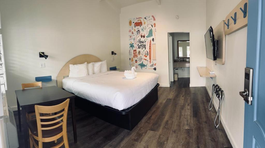皮斯莫比奇大洋棕榈汽车旅馆的一间卧室配有一张床和一张书桌及电视