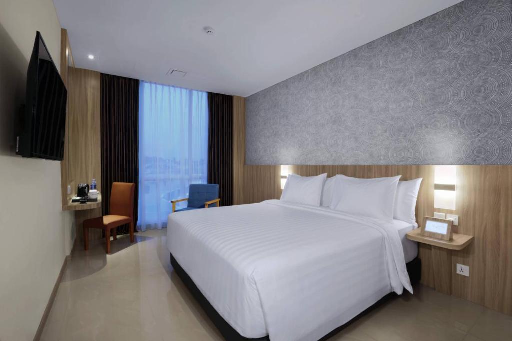 巴淡岛中心ASTON Nagoya City Hotel的一张大白色的床,位于酒店客房内