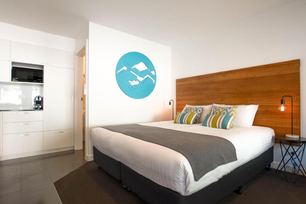 布赖特Bright Colonial Motel的一间卧室配有一张大床,墙上挂着蓝色标志