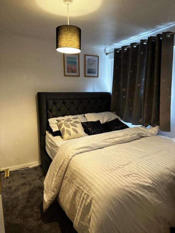 AddingtonLovely room in South London的一间卧室配有一张带黑色床头板的床