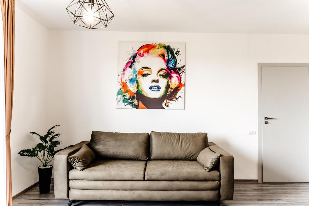 百乐费利克斯Ego Apartments的客厅配有沙发和一幅女人画